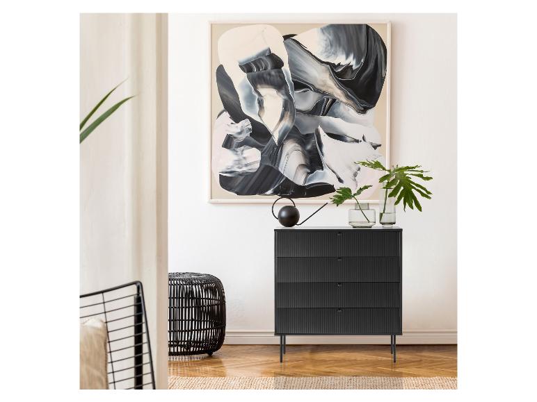 Commode noire avec façades sculptées, vases avec plantes et arrosoir, et une peinture abstraite au-dessus.