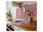 Moderne keuken met houten aanrechtblad, zwarte kookplaat en roze marmerlook tegels.