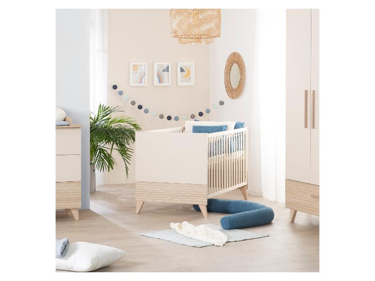 Une chambre de bébé avec un lit à barreaux, une commode et une armoire aux couleurs claires.