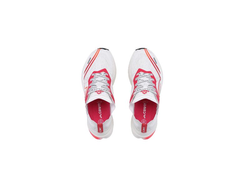 Paar witte hardloopschoenen met rode en oranje accenten, van bovenaf gezien.
