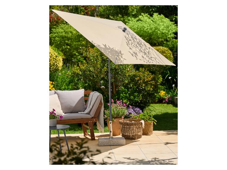 Parasol de terrasse ombrageant un banc de jardin et des plantes en pot sur un patio ensoleillé.