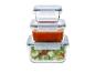 Pile de trois récipients en verre avec couvercles bleus, contenant salade, sauce tomate et un vide.