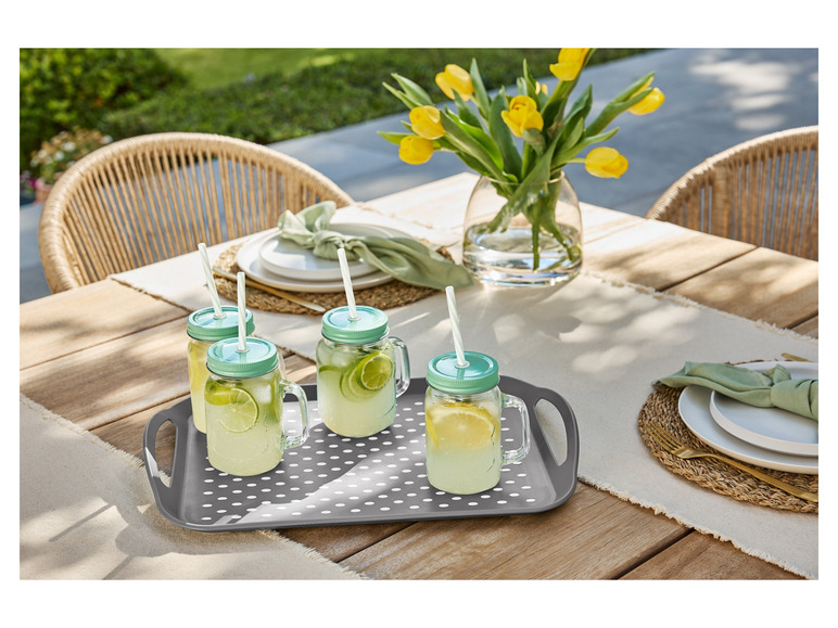 Boissons dans des verres avec des pailles sur un plateau gris à pois blancs.