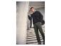 Homme en veste noire doublée de blanc, t-shirt noir et pantalon cargo vert.