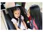 Mère et enfant en voiture, enfant souriant dans un siège auto, mère regardant l'enfant.