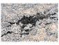 Tapis moelleux aux tons gris, beige et noir.