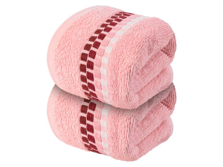 Twee roze handdoeken met een geometrisch patroon.