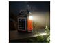 Batterie externe solaire portable avec lampe de poche et ports USB sur une table en bois la nuit