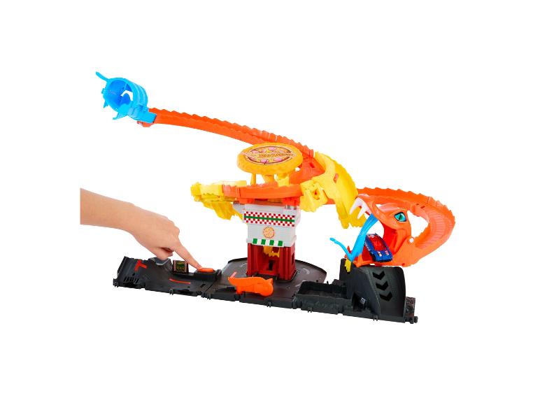 Piste de pizza Hot Wheels City avec une main appuyant sur un bouton.