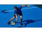 Homme en tenue de sport jouant au padel sur un court bleu.