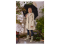Vrouw in beige regenjas en laarzen met luipaardprint.