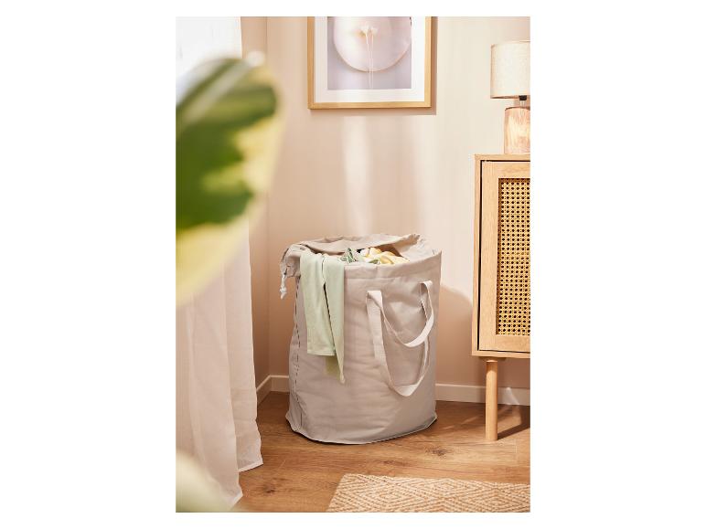 Panier à linge beige et meuble en rotin.