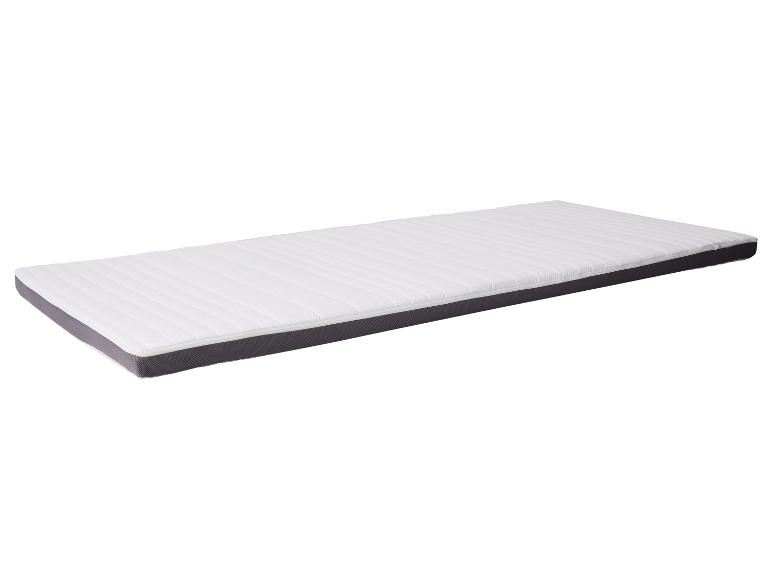 Surmatelas blanc avec bordure grise sur fond blanc.