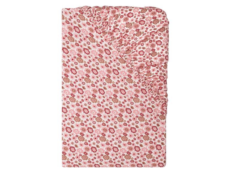 Drap-housse pour lit bébé avec motif floral rose et marron.