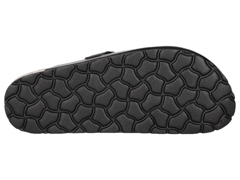 Semelle d'une sandale noire avec une surface texturée.
