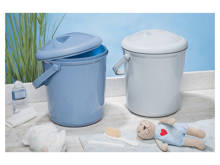 Deux baignoires pour bébé, des couches, une brosse et un ours en peluche.