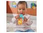 Un bébé assis jouant avec un hochet jouet jaune et bleu.