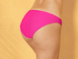 Een vrouw draagt een roze bikini-onderdeel.