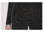 Gros plan d'une robe noire scintillante avec un bracelet argenté au bras.