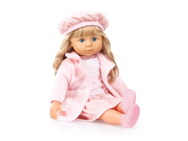 Pop met blond haar en blauwe ogen in roze kleding met een hoed