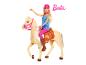 Barbiepop rijdend op een paard met roze zadel en hoofdstel, op een witte achtergrond.