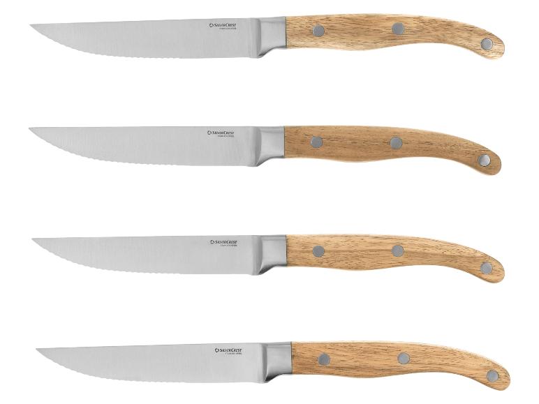 Ensemble de quatre couteaux à steak avec lames dentelées et manches en bois.