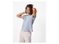 Femme en t-shirt bleu clair et pantalon de survêtement rose, les mains derrière la tête.