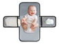 Een baby op een grijs verschoningskleed met luier, doekjes en een zakje