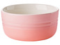 Een roze Le Creuset kom met een witte binnenkant.