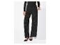 Pantalon large noir pailleté et haut assorti, portés avec des talons noirs.