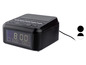 Un radio-réveil numérique noir avec chargeur intégré.