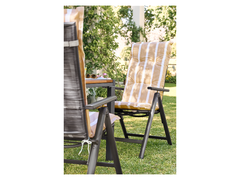 Twee opvouwbare tuinstoelen met gestreepte kussens op het gras.