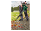 Een man gebruikt een Parkside bladblazer om herfstbladeren op te ruimen.