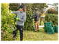 Deux personnes taillent des arbustes avec des outils Parkside dans un jardin.