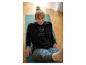 Vrouw in zwarte Jette Sport hoodie en bedrukte legging op een yogamat.