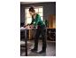 Femme en chemise verte et pantalon de travail noir avec des accents rouges, travaillant à un établi.