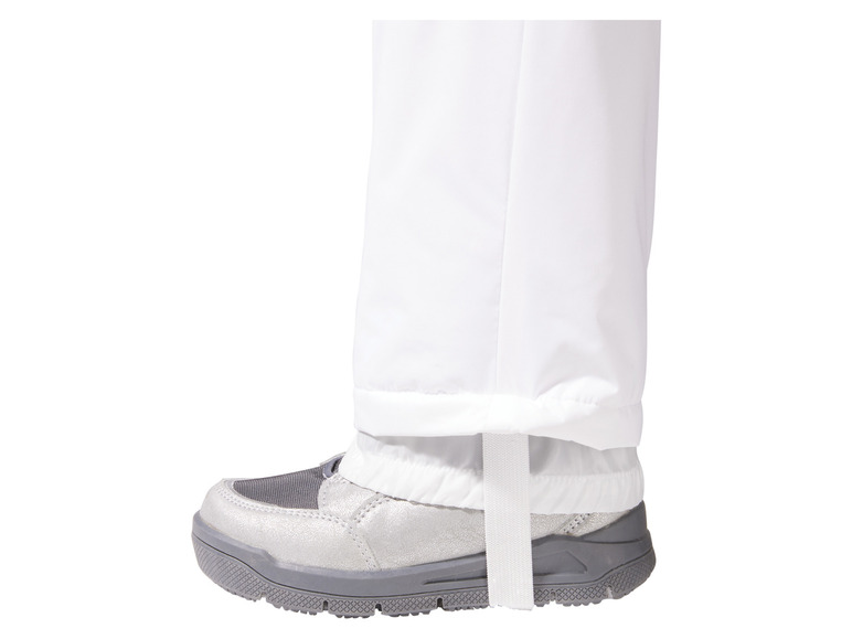 Pantalon blanc avec élastique en bas et chaussures argentées.