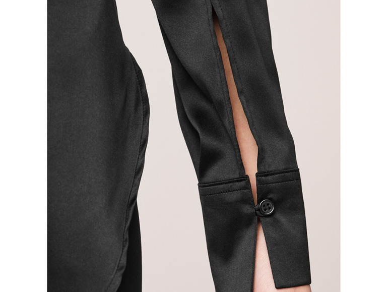 Une chemise noire en satin à manches longues avec des fentes aux manches.