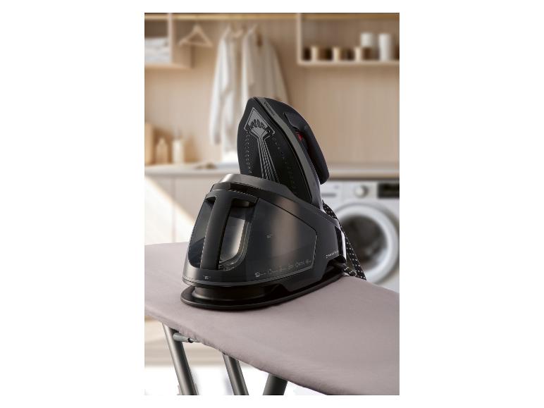 Fer à repasser à vapeur sur une planche à repasser dans une buanderie.