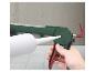 Een hand houdt een groen en rood kitpistool vast met een witte kitkoker erin.