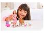 Barbiepop en hondenspeelgoed met een meisje dat op de achtergrond speelt.