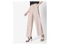 Vrouw draagt beige wijde broek en zwarte sandalen met hoge hakken