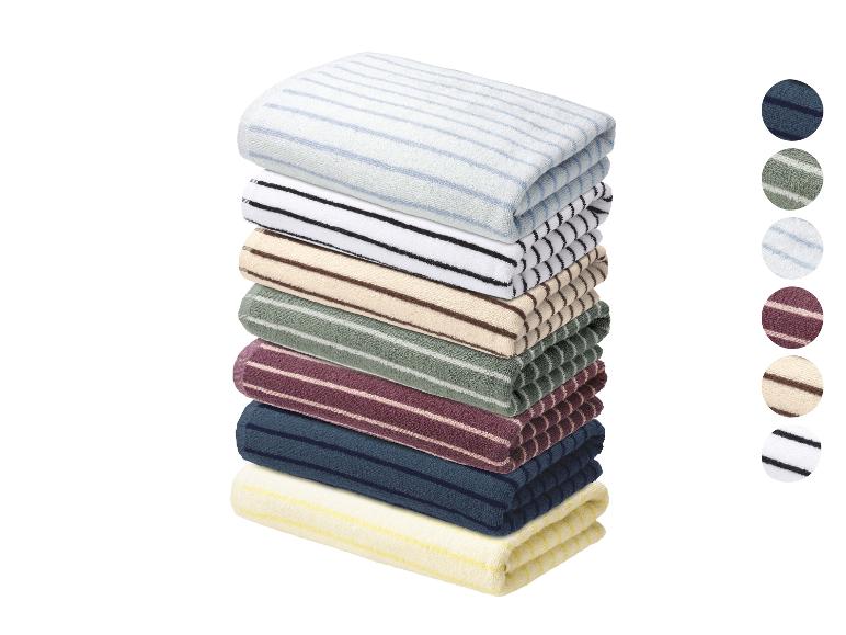 Stapel gestreepte handdoeken in diverse kleuren met ronde kleurstaaltjes.