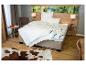 Slaapkamer met bed, wit beddengoed en houten meubels, met bosthema op het hoofdeinde.