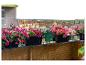 Système d'arrosage sur un balcon fleuri avec vue sur la ville.