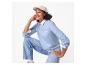 Vrouw in lichtblauwe sweatshirt met 'Breakfast Club'-opdruk, jeans en pet.
