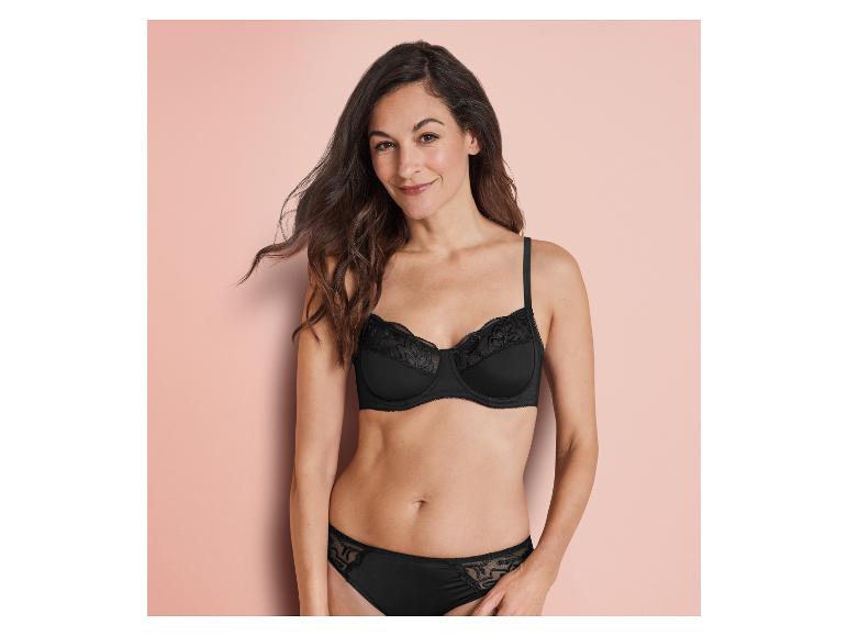 Une femme porte un soutien-gorge et une culotte noirs en dentelle.
