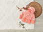 Un cardigan rose en tricot à capuche pour bébés.