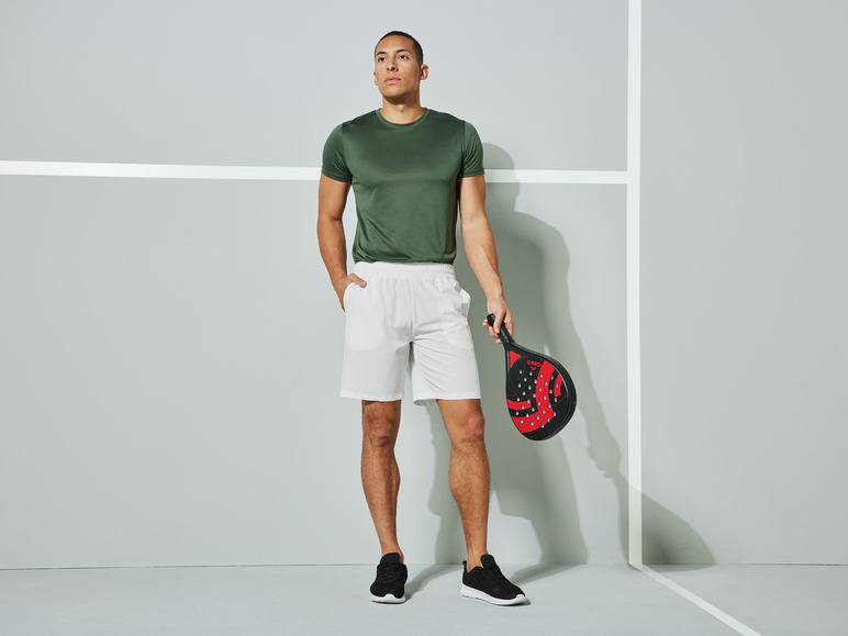 Un homme en tenue de sport tenant une raquette de paddle.