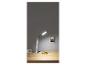 Lampe de bureau blanche avec téléphone sur bureau en bois, à côté d'un haut-parleur et d'un carnet.